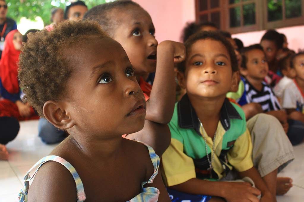 Preschool children in Africa looking up during a lesson