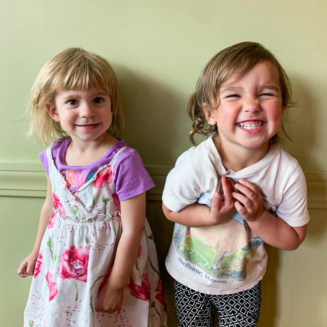 Two toddlers smiling big for the camera