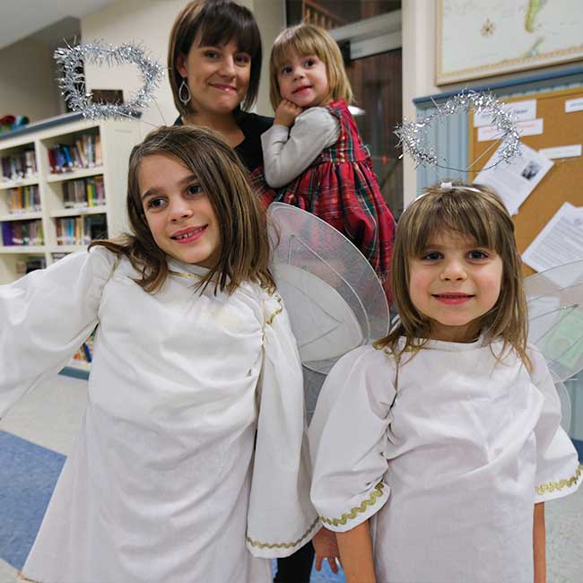 Family with two girls dressed as angels for Christmas pageant
