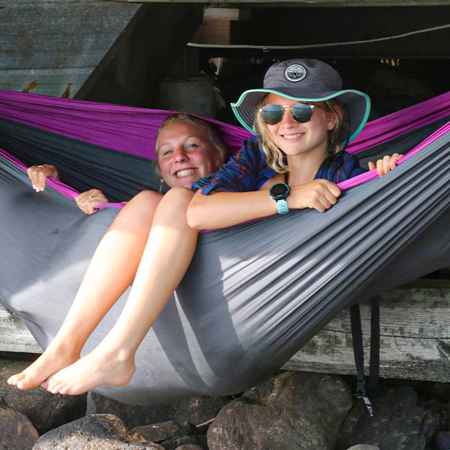 Two Jericho Congregational youth sitting in a hammock smiling